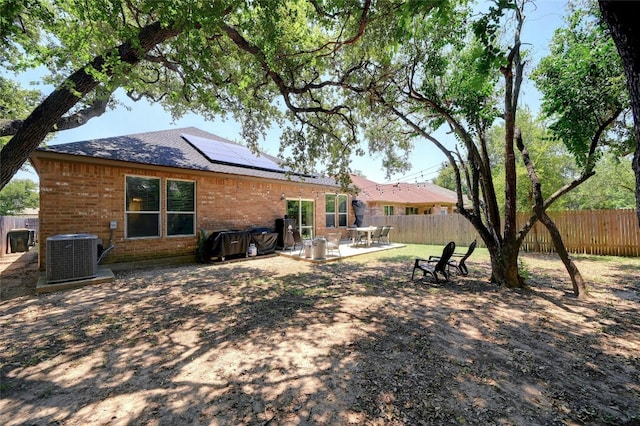 rear view of property with solar panels, central AC, and a patio area