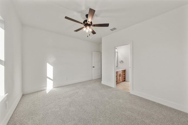 unfurnished bedroom featuring connected bathroom, ceiling fan, and light carpet