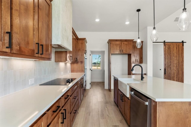 kitchen featuring black electric stovetop, a barn door, dishwasher, light hardwood / wood-style floors, and hanging light fixtures