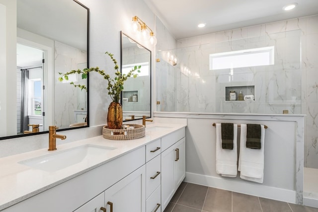 bathroom featuring a healthy amount of sunlight, vanity, and a tile shower