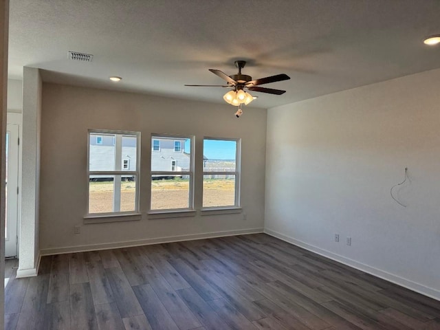 spare room with dark wood-type flooring and ceiling fan