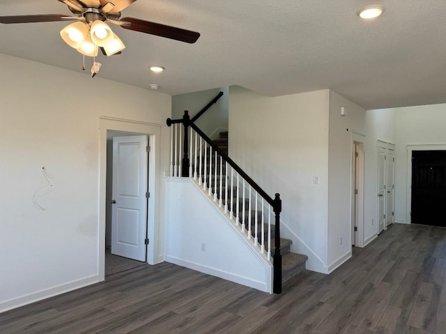 stairs featuring wood-type flooring and ceiling fan