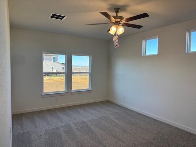 empty room featuring ceiling fan and carpet