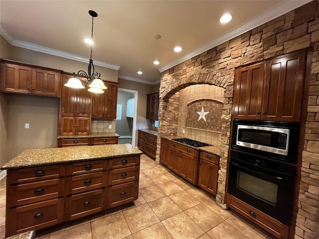 kitchen featuring light stone countertops, a center island, hanging light fixtures, an inviting chandelier, and black appliances