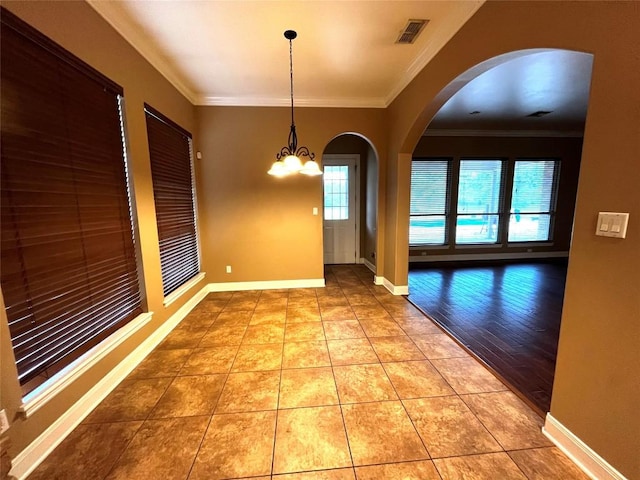 unfurnished dining area with light hardwood / wood-style floors, crown molding, and an inviting chandelier