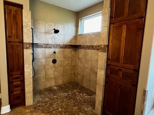 bathroom with tiled shower and tile patterned floors