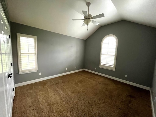 carpeted empty room with a wealth of natural light, ceiling fan, and lofted ceiling