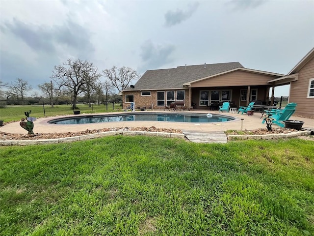 view of pool with a lawn and a patio area