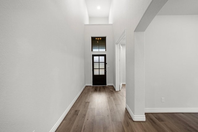 doorway to outside featuring hardwood / wood-style floors and a high ceiling