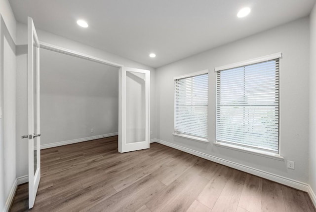 unfurnished bedroom featuring french doors and light hardwood / wood-style flooring