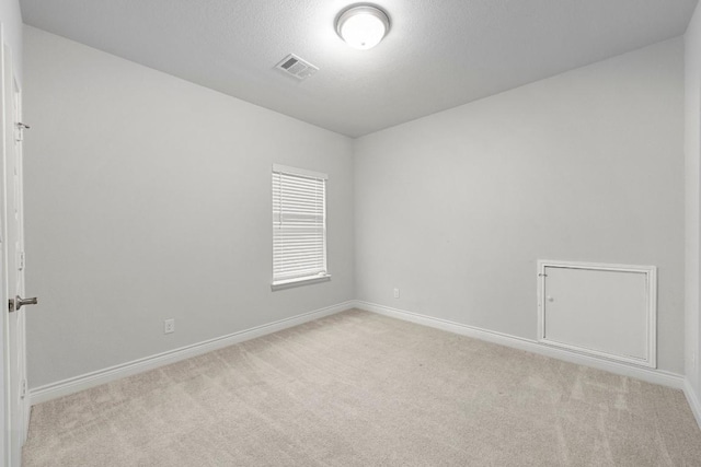 carpeted spare room with a textured ceiling