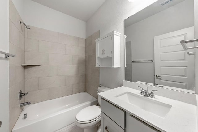 full bathroom featuring vanity, tiled shower / bath combo, and toilet