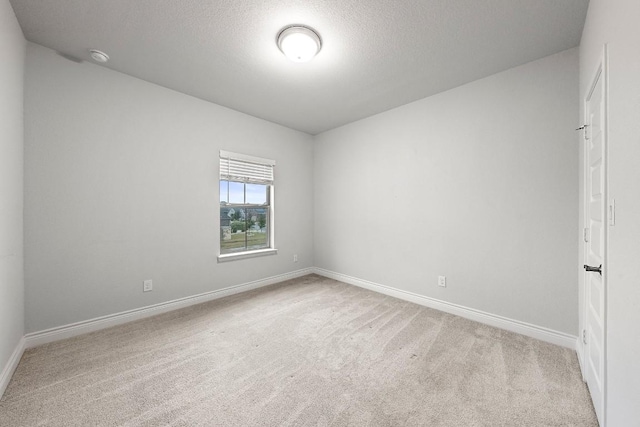 empty room featuring a textured ceiling and light carpet