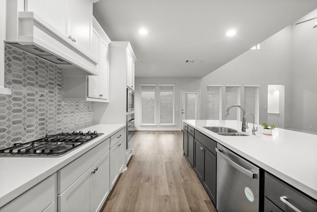 kitchen with white cabinets, appliances with stainless steel finishes, tasteful backsplash, and sink