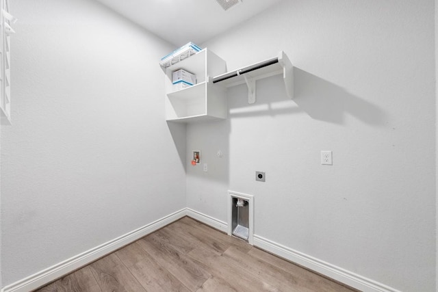 washroom featuring electric dryer hookup, light hardwood / wood-style floors, gas dryer hookup, and hookup for a washing machine