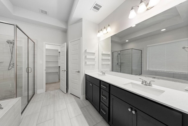 bathroom featuring a shower with door and vanity