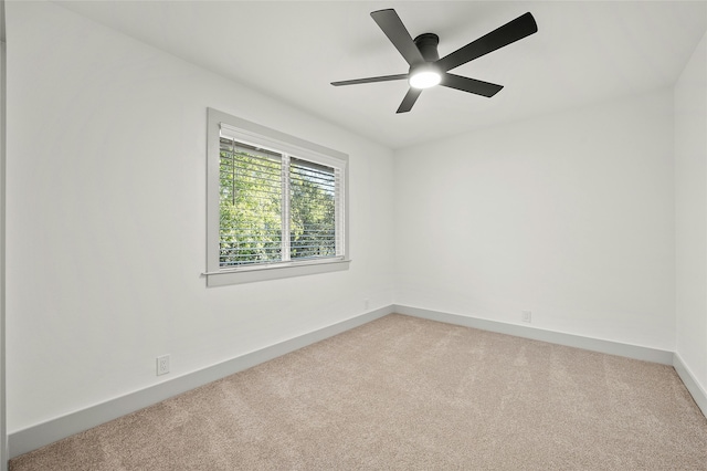 spare room with ceiling fan and light carpet