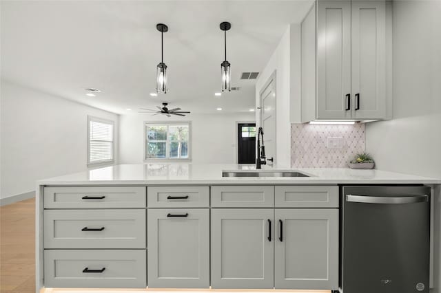 kitchen with stainless steel dishwasher, sink, decorative light fixtures, ceiling fan, and gray cabinets