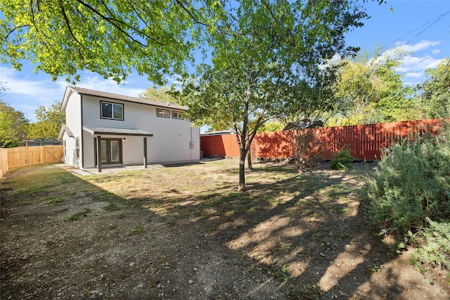 rear view of house with a patio and a lawn