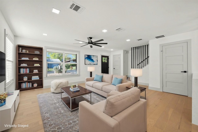 living room featuring ceiling fan and light hardwood / wood-style floors