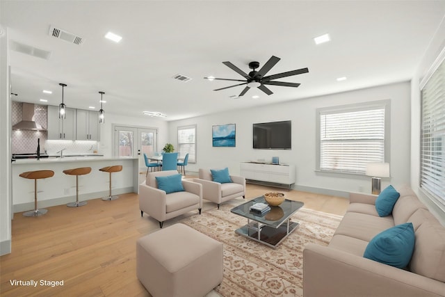 living room featuring light hardwood / wood-style floors and ceiling fan