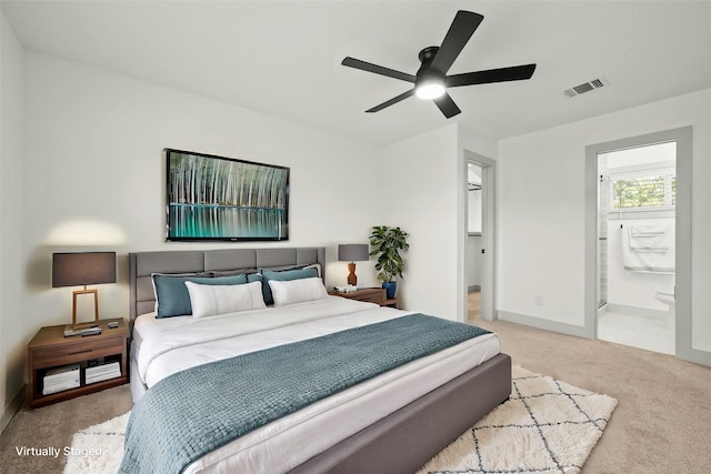 carpeted bedroom featuring ceiling fan and ensuite bath