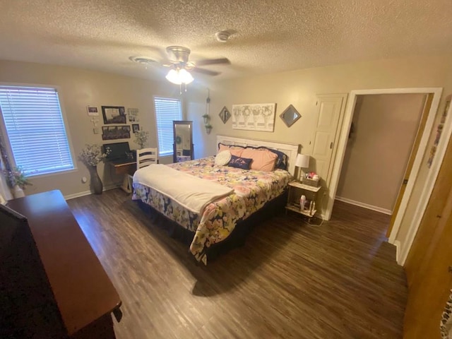 bedroom with ceiling fan, dark hardwood / wood-style flooring, and a textured ceiling