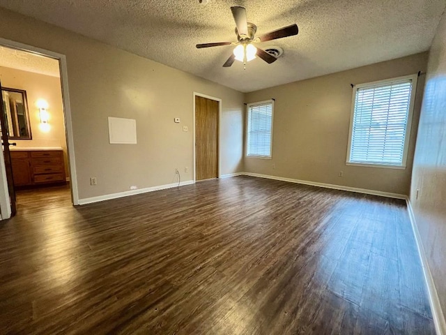 unfurnished bedroom featuring multiple windows, ceiling fan, dark hardwood / wood-style flooring, and a textured ceiling