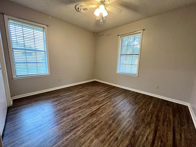 unfurnished room with a textured ceiling, plenty of natural light, ceiling fan, and dark wood-type flooring