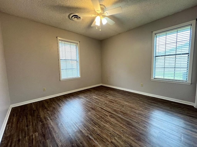 empty room featuring ceiling fan, dark wood-type flooring, and a textured ceiling