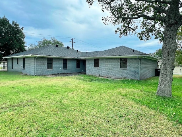 rear view of property with a lawn