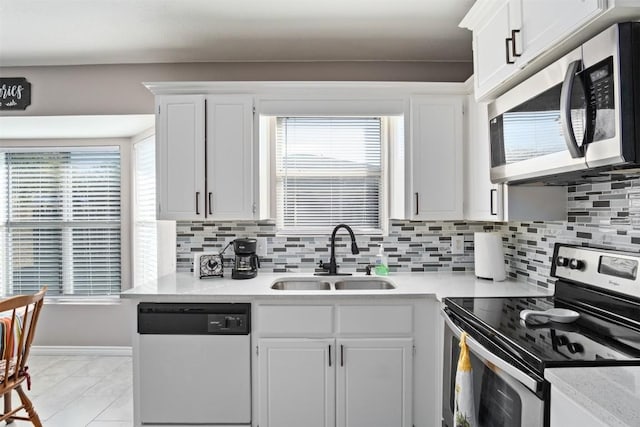 kitchen with light countertops, tasteful backsplash, appliances with stainless steel finishes, and a sink