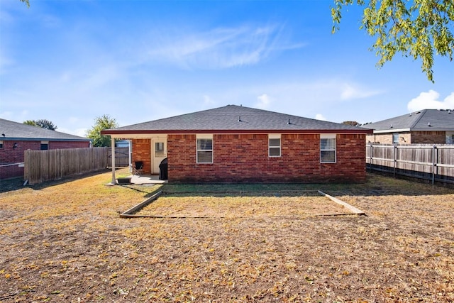 rear view of house with brick siding, a lawn, a patio, and a fenced backyard