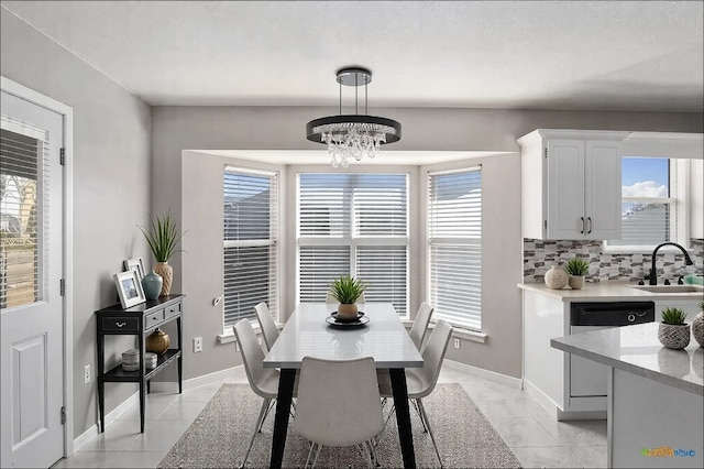 dining room featuring baseboards, a chandelier, and plenty of natural light
