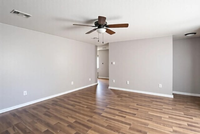 unfurnished room featuring visible vents, baseboards, a ceiling fan, and wood finished floors