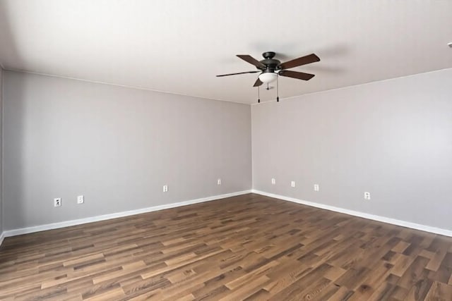 empty room featuring baseboards, a ceiling fan, and dark wood-style floors