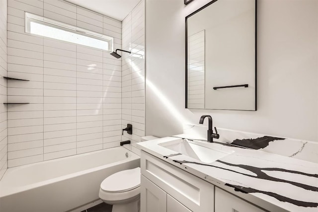 full bathroom featuring vanity, tiled shower / bath combo, and toilet