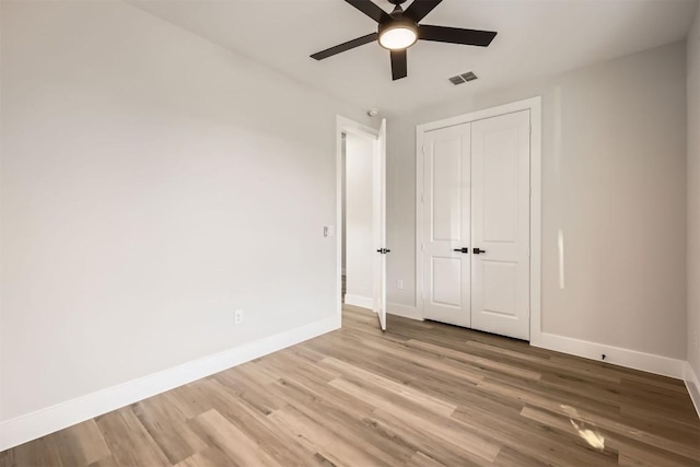 unfurnished bedroom with light wood-type flooring, a closet, and ceiling fan