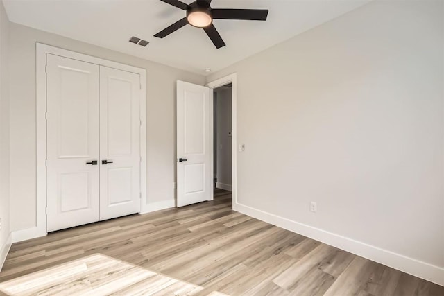 unfurnished bedroom featuring ceiling fan, a closet, and light hardwood / wood-style flooring