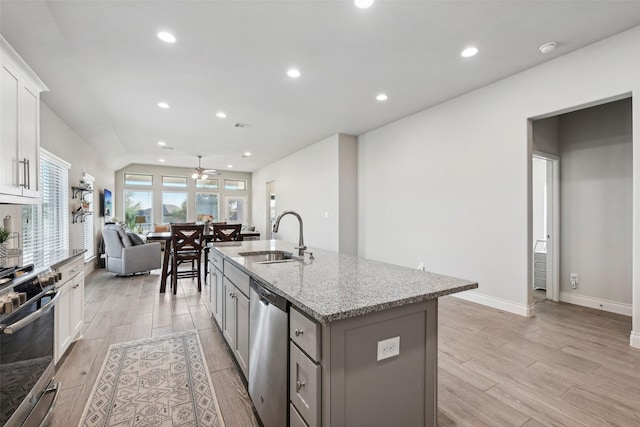 kitchen featuring sink, white cabinetry, a kitchen island with sink, light stone countertops, and appliances with stainless steel finishes