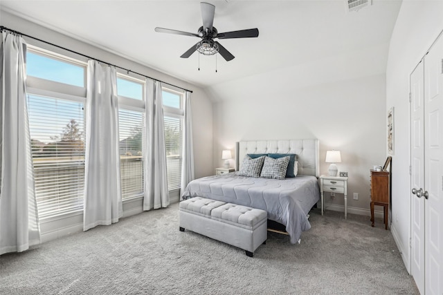 carpeted bedroom with ceiling fan and vaulted ceiling