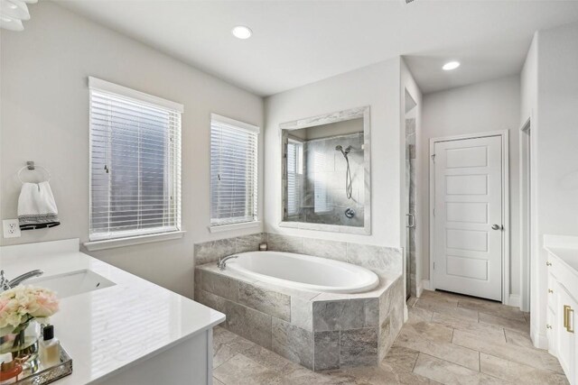 120 Krupp Ave, Liberty Hill, TX 78642 - full bathroom with vanity, a shower stall, a garden tub, recessed lighting, and stone tile flooring