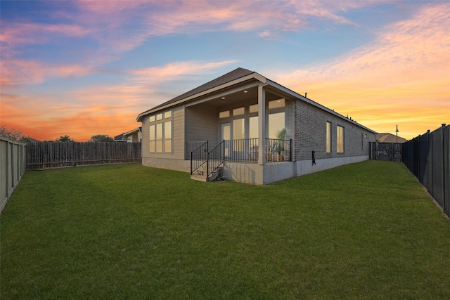 property exterior at dusk featuring a lawn