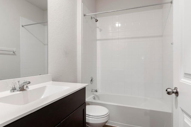 full bathroom featuring tiled shower / bath, vanity, and toilet