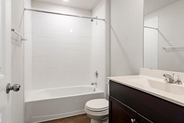 full bathroom featuring tiled shower / bath combo, toilet, wood-type flooring, and vanity