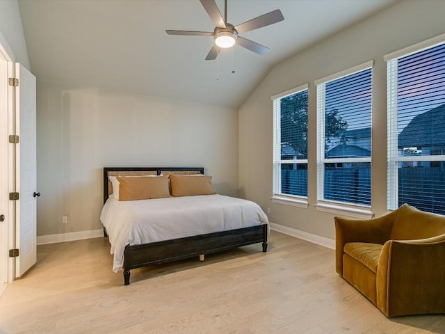 bedroom with ceiling fan, light hardwood / wood-style floors, and vaulted ceiling