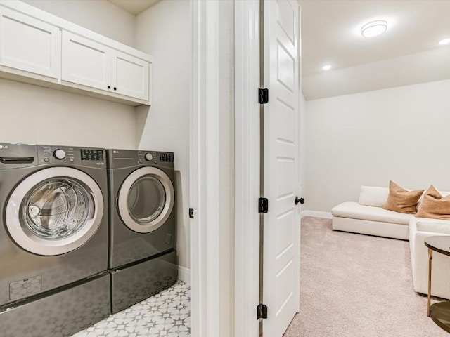 laundry area with cabinets, light carpet, and washer and clothes dryer