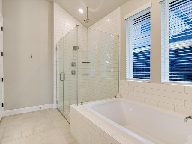 bathroom with tile patterned floors, separate shower and tub, a wealth of natural light, and lofted ceiling