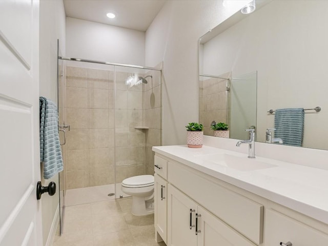 bathroom featuring tile patterned floors, a shower with door, vanity, and toilet