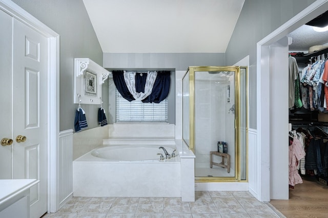 bathroom featuring tile patterned floors, plus walk in shower, and vaulted ceiling